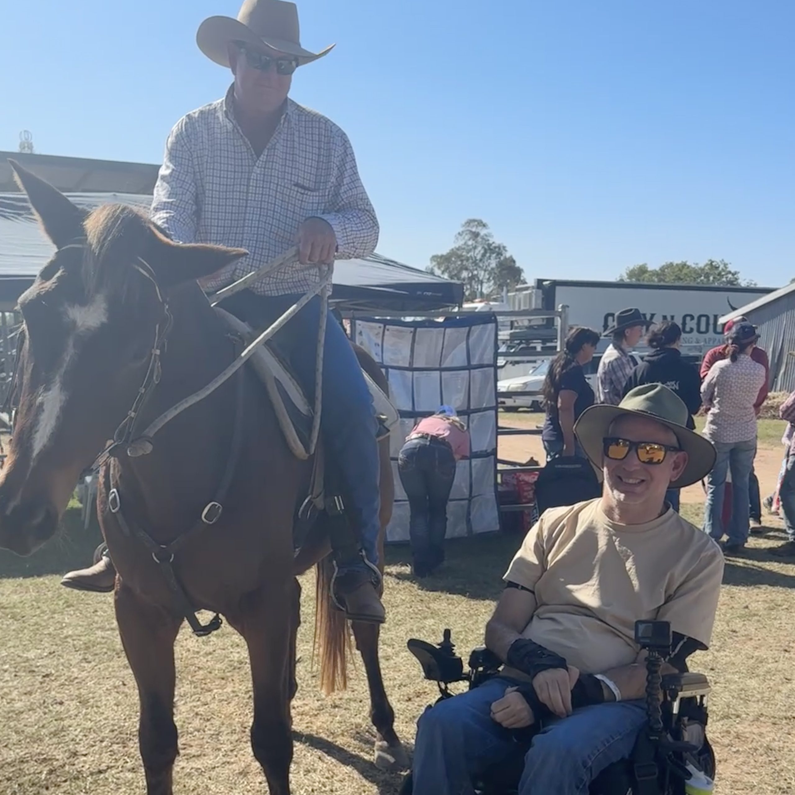 a person in a wheelchair, next to a horse & cowboy